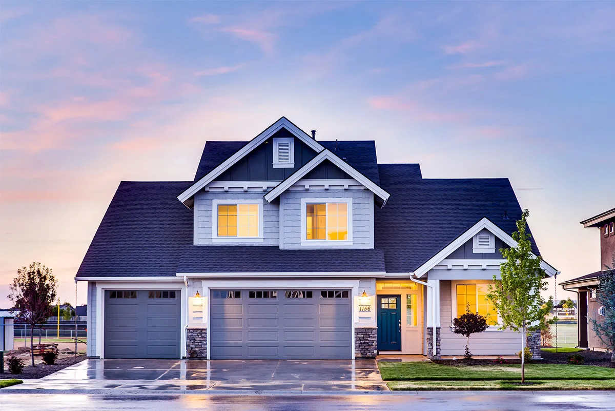 A two-story house with a three-car garage at dusk